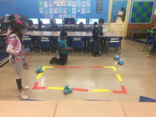 Programming Dash robots to go around a track designed by the students